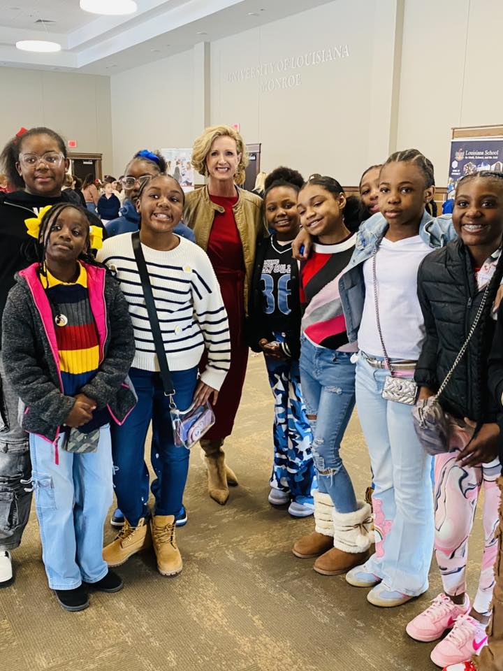 A woman and a group of kids posing for a picture.